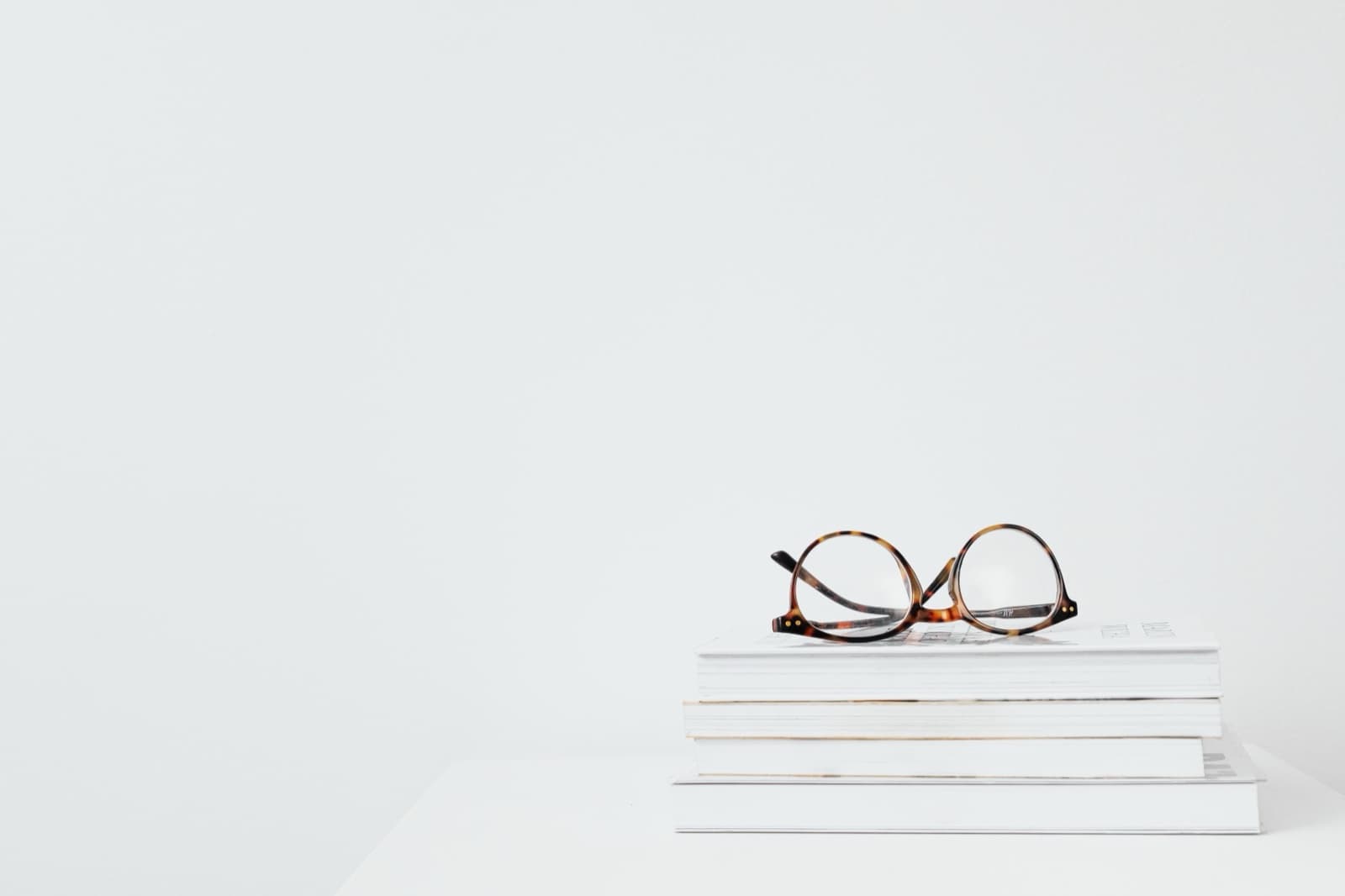 Reading glasses resting on a stack of documents